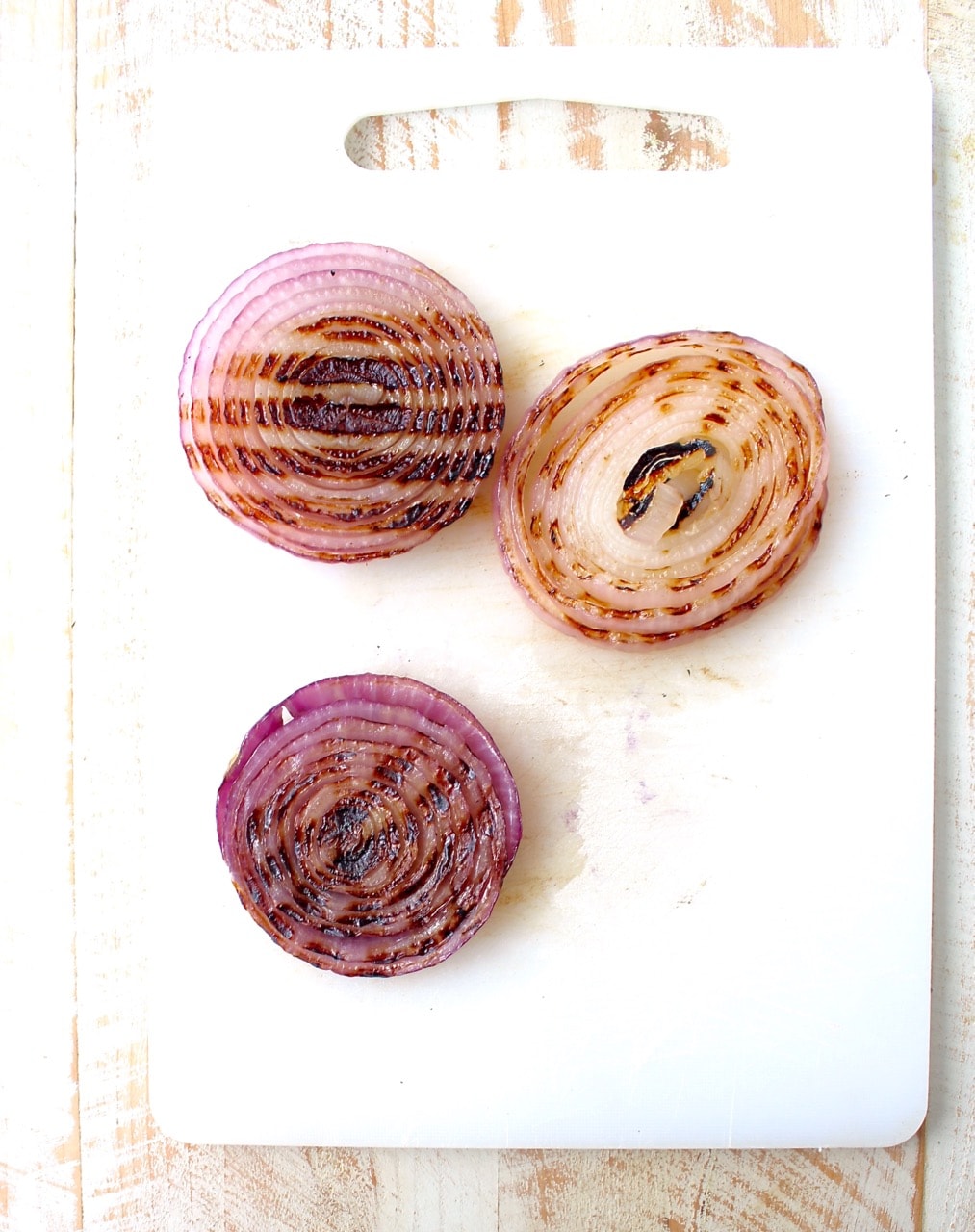 grilled slices of onions on cutting board