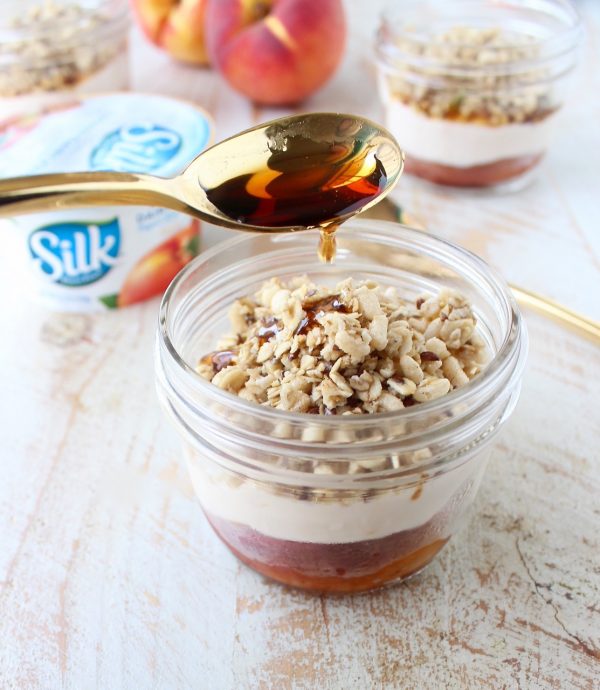 Cinnamon sugar grilled peaches are layered with peach almond milk yogurt and granola in this delicious vegan parfait recipe, great for breakfast or dessert!