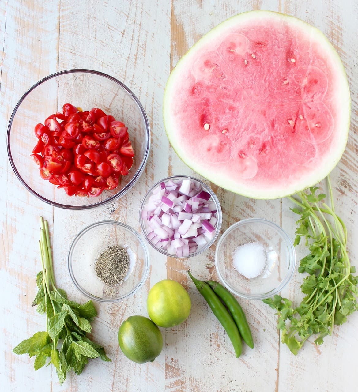 watermelon salsa ingredients on white wood board