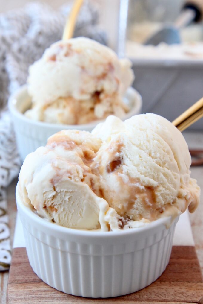 scoops of salted caramel ice cream in white bowl with gold spoon
