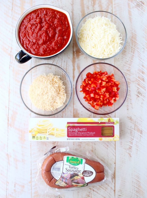 Toss your favorite pizza toppings, like sausage & peppers, with spaghetti & pasta sauce, then top with cheese for an easy pizza baked spaghetti recipe!