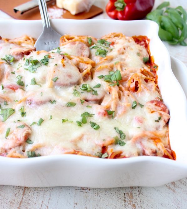 Toss your favorite pizza toppings, like sausage & peppers, with spaghetti & pasta sauce, then top with cheese for an easy pizza baked spaghetti recipe!