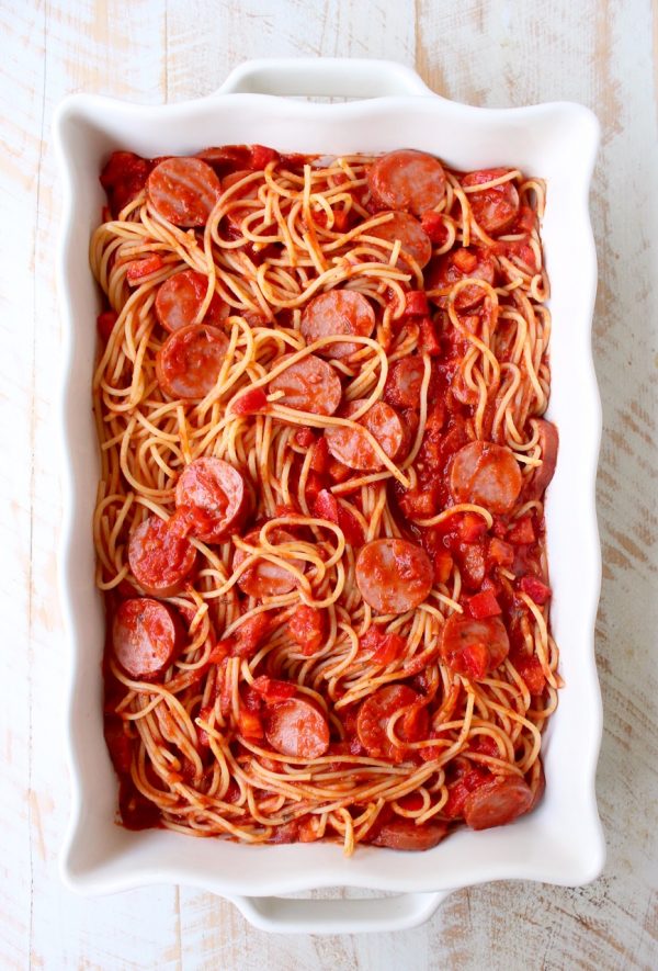 Toss your favorite pizza toppings, like sausage & peppers, with spaghetti & pasta sauce, then top with cheese for an easy pizza baked spaghetti recipe!