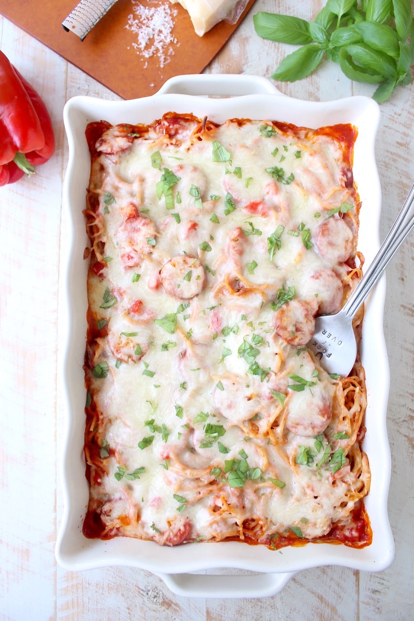 Toss your favorite pizza toppings, like sausage & peppers, with spaghetti & pasta sauce, then top with cheese for an easy pizza baked spaghetti recipe!