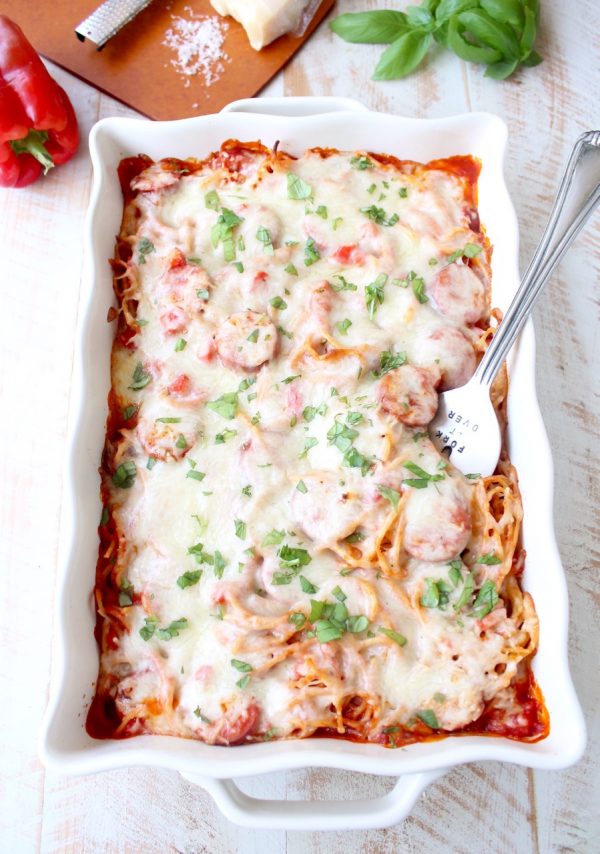 Toss your favorite pizza toppings, like sausage & peppers, with spaghetti & pasta sauce, then top with cheese for an easy pizza baked spaghetti recipe!