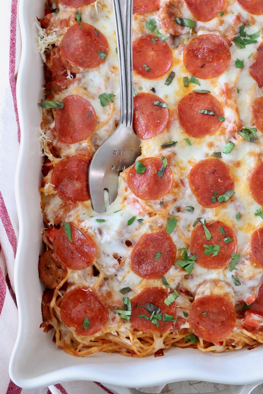 pizza baked spaghetti in casserole dish with large serving fork