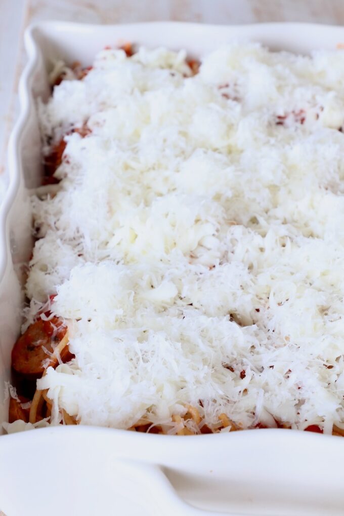 uncooked spaghetti casserole topped with shredded mozzarella and parmesan cheese