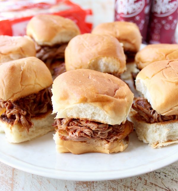 Hawaiian roll pulled pork sandwiches on a white plate.