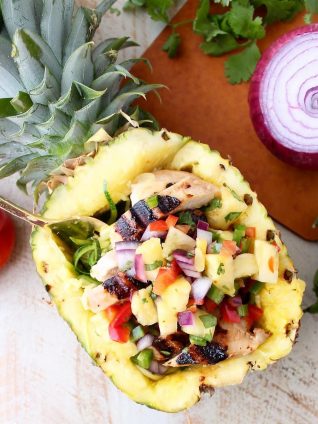 Grilled chicken teriyaki is served over zucchini noodles and topped with pineapple salsa in these healthy, gluten free and delicious zoodle bowls!