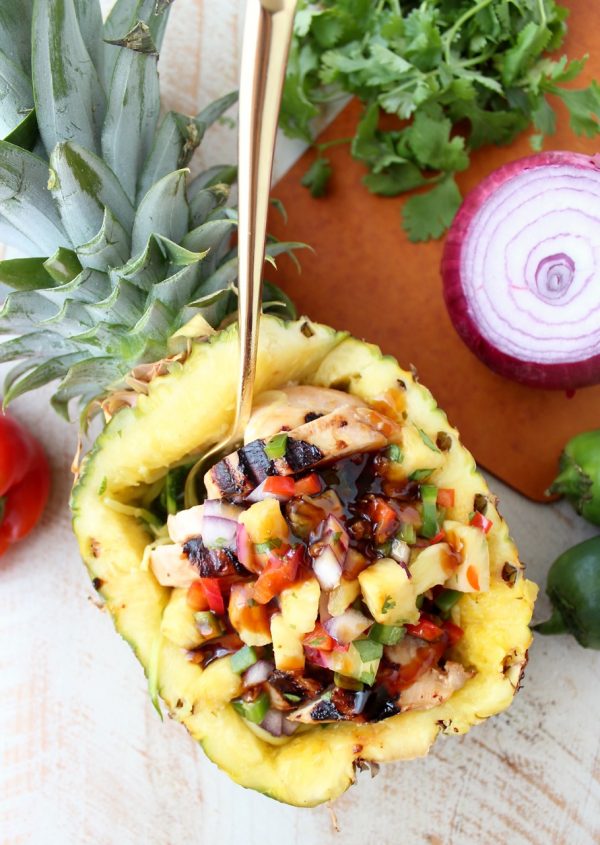 Grilled teriyaki chicken is served over zucchini noodles and topped with pineapple salsa in these healthy, gluten free and delicious zoodle bowls!