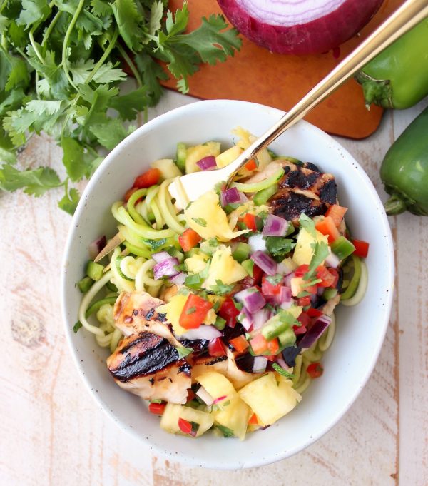 Grilled teriyaki chicken is served over zucchini noodles and topped with pineapple salsa in these healthy, gluten free and delicious zoodle bowls!