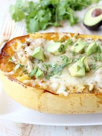 Green chili chicken is stuffed in roasted spaghetti squash and topped with gooey, melted pepper jack cheese for a delicious gluten free fall meal!