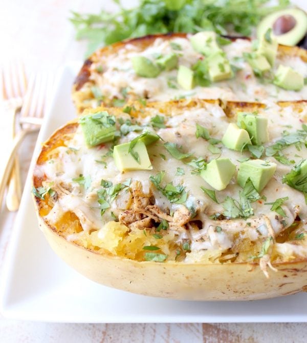 roasted spaghetti squash on plate filled with chicken, cheese and diced avocado