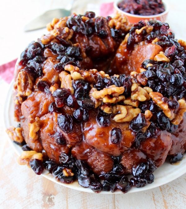 Maple syrup, dried cranberries and walnuts top this decadent monkey bread recipe that's perfect for fall brunches and holiday breakfasts!