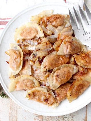 In this easy pierogies recipe, wonton wrappers are filled with leftover mashed potatoes, then pan seared with caramelized onions for a delicious meal!