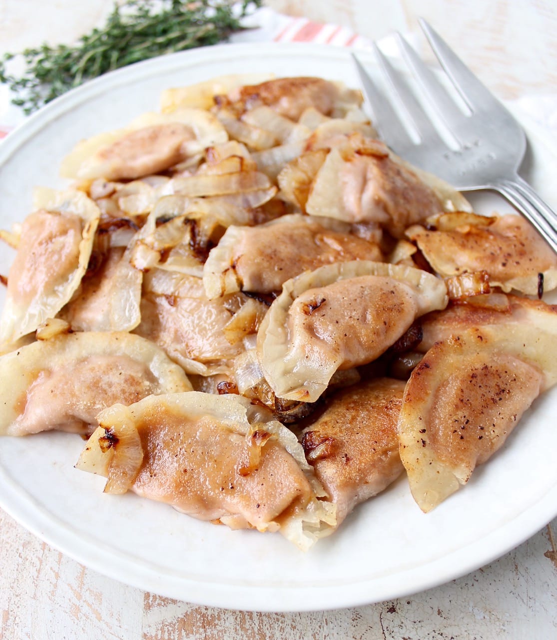 In this easy pierogies recipe, wonton wrappers are filled with leftover mashed potatoes, then pan seared with caramelized onions for a delicious meal!