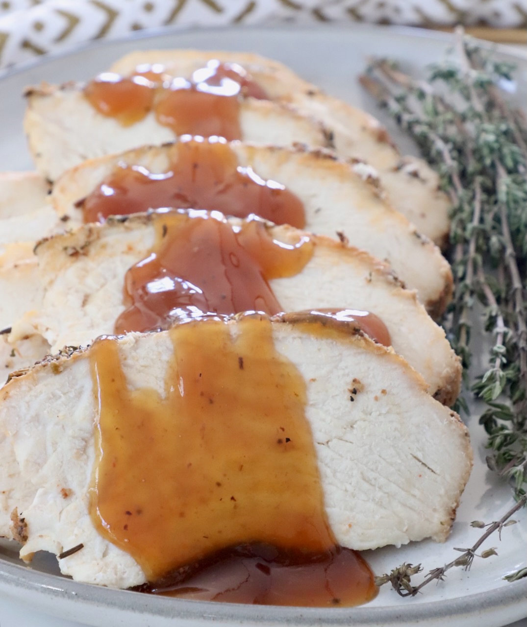 slices of turkey on a plate with a maple glaze drizzled over the turkey