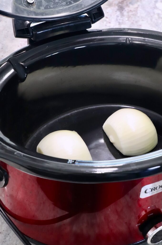 onion cut in half in a crock pot