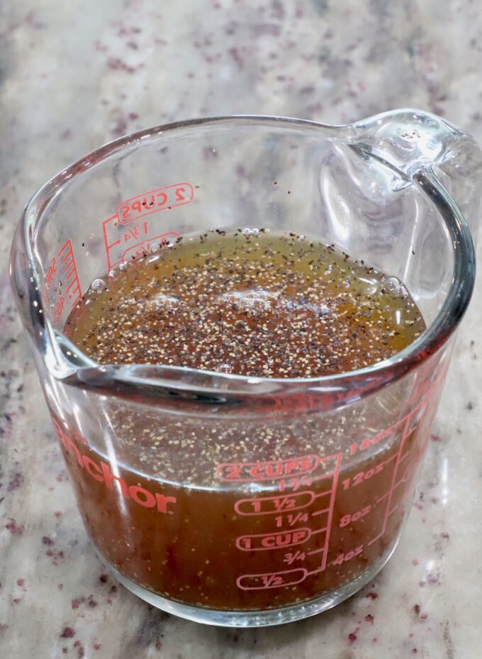 maple syrup and apple cider combined in a glass measuring cup with salt and pepper