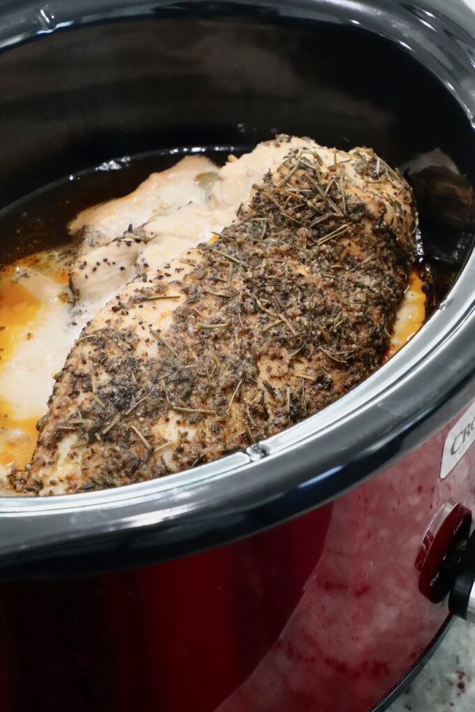 cooked seasoned turkey breast in a crock pot