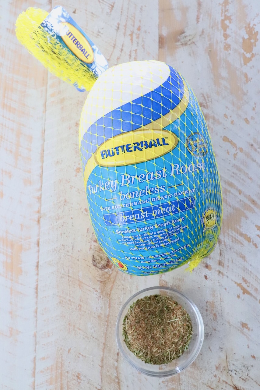 boneless turkey breast in packaging next to a bowl of turkey seasoning