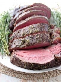 An oven roasted herb crusted beef tenderloin is a show stopping dinner recipe, served with a mouth-watering creamy horseradish gorgonzola sauce.