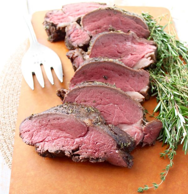 Slices of beef tenderloin on a cutting board. 