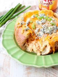 Everyone's favorite buffalo chicken dip is baked right into a bread bowl for the perfect party, game day or weekend appetizer!