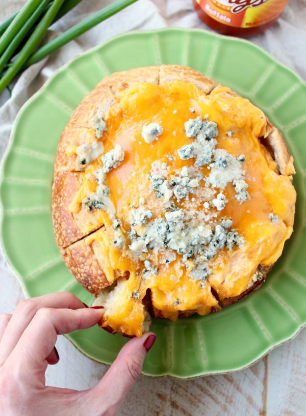 Everyone's favorite buffalo chicken dip is baked right into a bread bowl for the perfect party, game day or weekend appetizer!