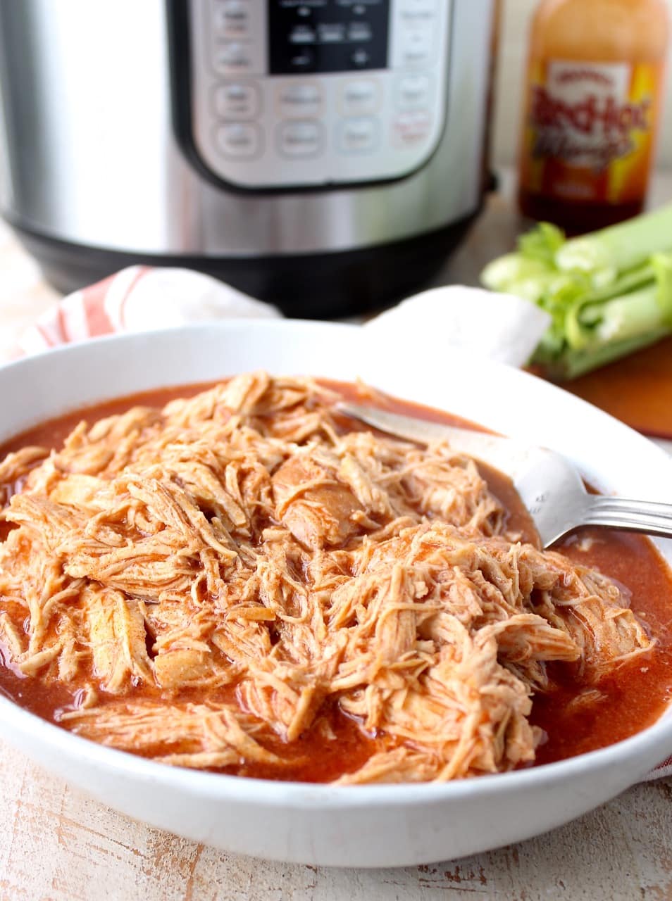 Easily make shredded buffalo chicken for tacos, dips or pasta recipes with this simple Instant Pot Buffalo Chicken recipe!
