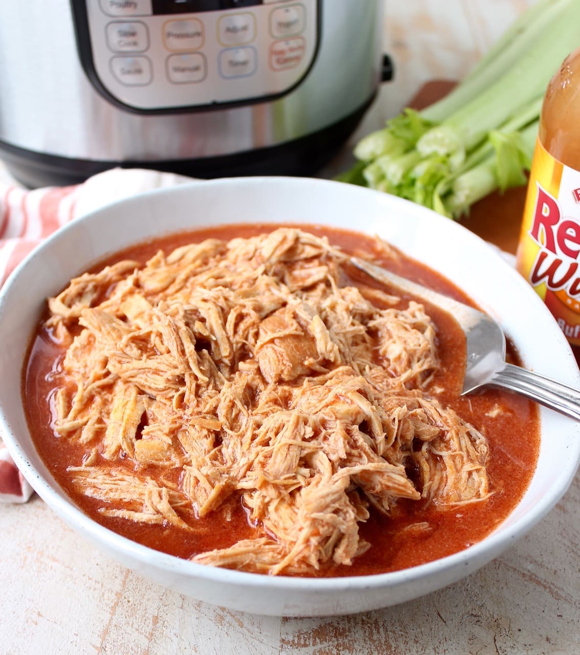 Easily make shredded buffalo chicken for tacos, dips or pasta recipes with this simple Instant Pot Buffalo Chicken recipe!