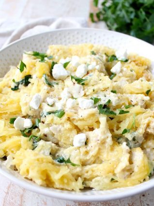 Baked spaghetti squash is tossed with a simple spinach artichoke sauce in this healthy, gluten free and vegetarian recipe, made in under an hour!