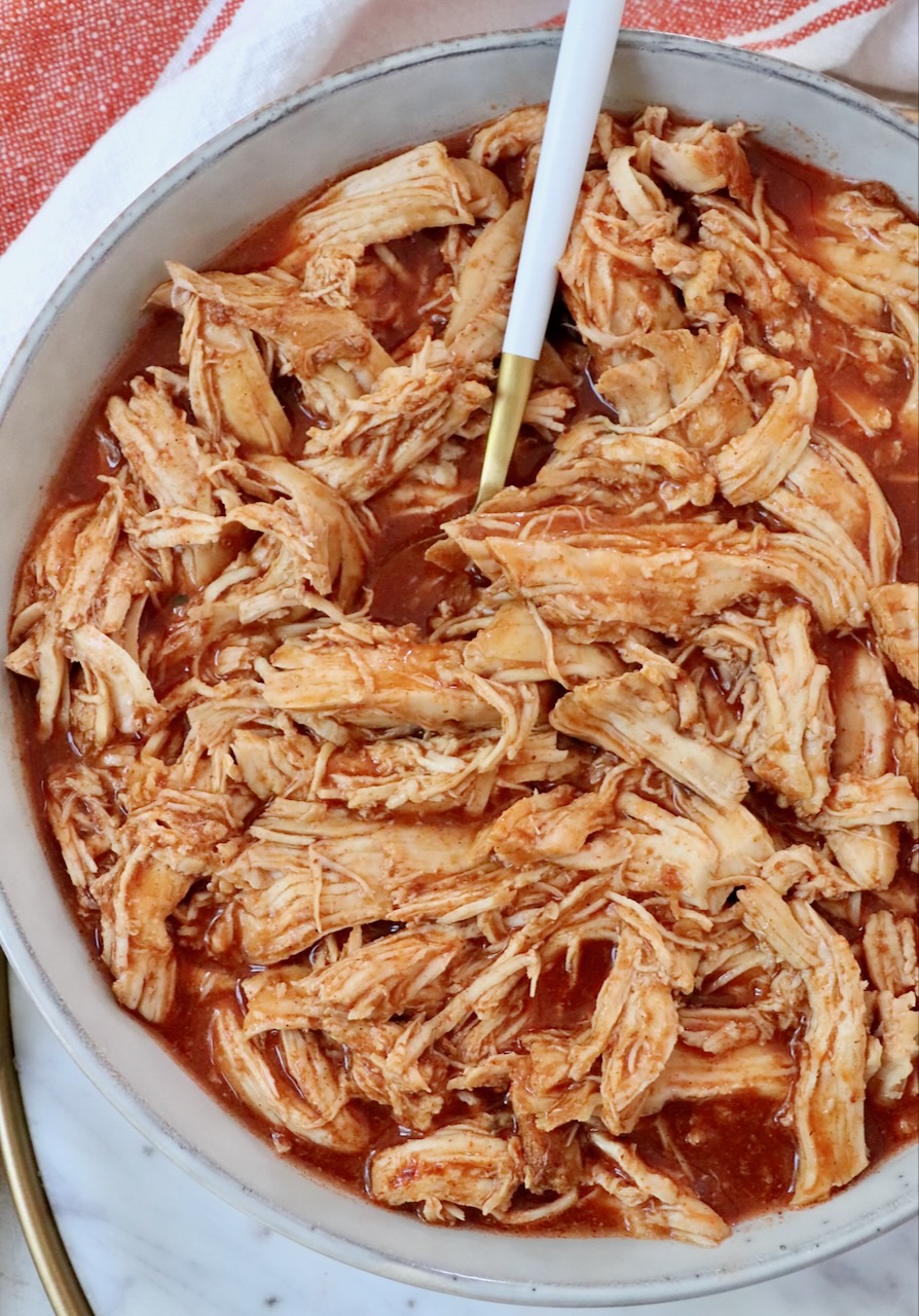 shredded chicken with buffalo sauce in bowl with fork