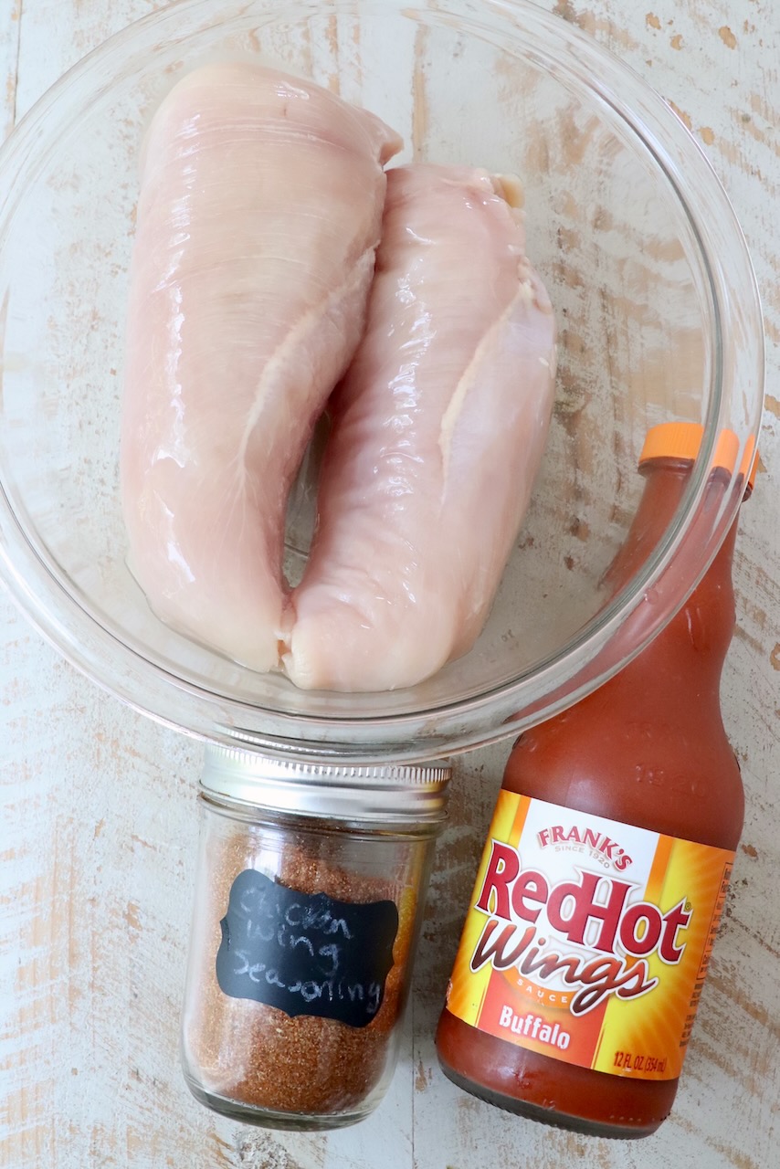 ingredients for Instant Pot buffalo chicken on a white wood board