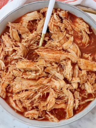 shredded chicken in buffalo sauce in a bowl with a fork