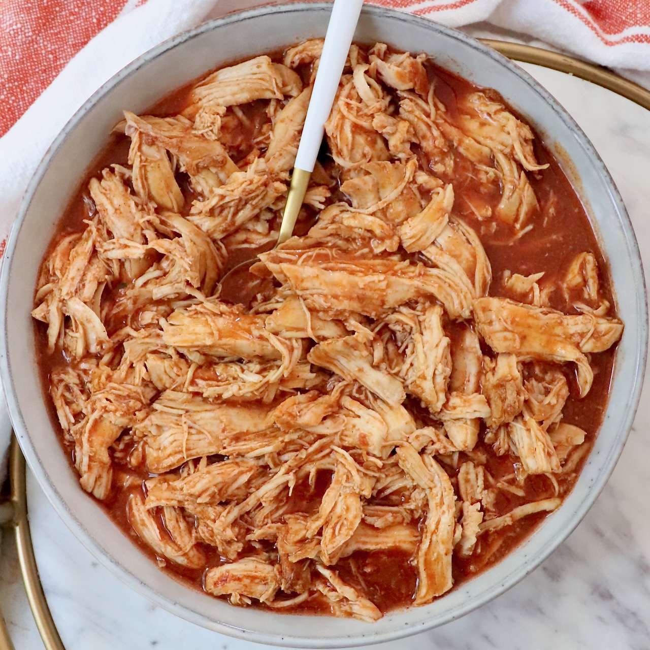 shredded chicken in buffalo sauce in a bowl with a fork