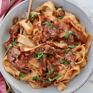 beef ragu sauce tossed with pasta noodles in a bowl with a fork