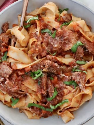 beef ragu sauce tossed with pasta noodles in a bowl with a fork