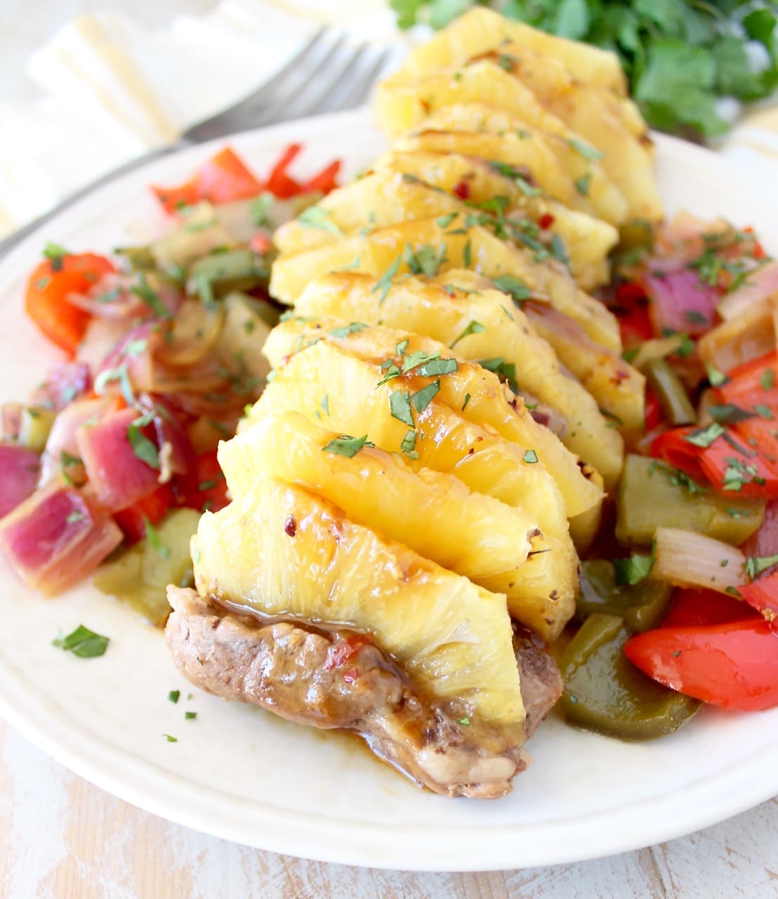 pork tenderloin filled with pineapple slices on a plate with vegetables