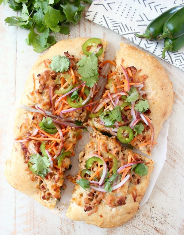 Turn your favorite banh mi sandwich into a pizza with this easy and delicious Banh Mi Pizza recipe, topped with sesame ginger ground pork, fresh carrots, jalapeños, cilantro and Sriracha!