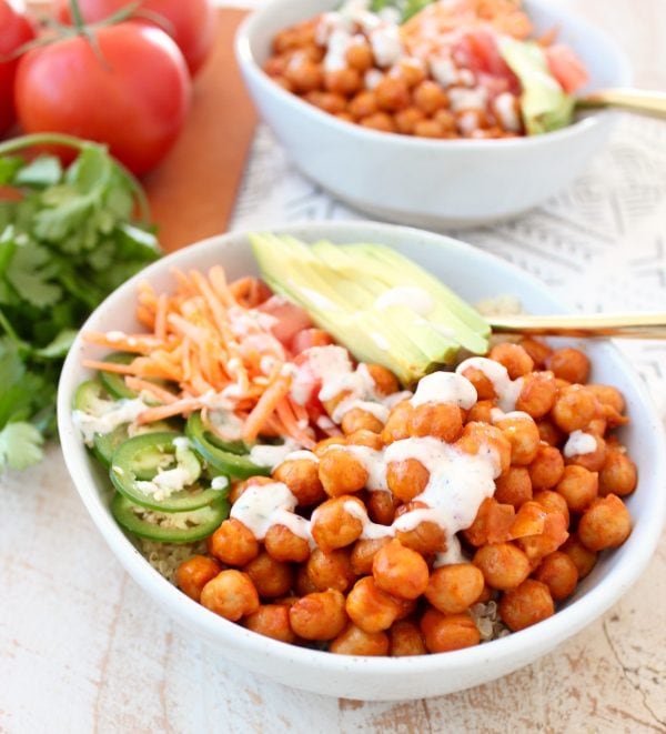 Buffalo chickpeas, quinoa and veggies are tossed together in this healthy, gluten free, vegan buddha bowl recipe, topped with an easy homemade vegan ranch dressing, all made in just 20 minutes!