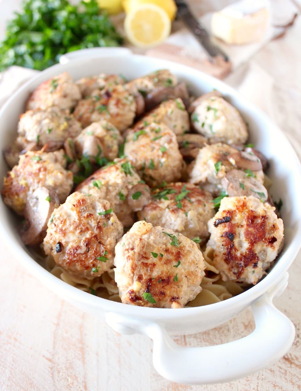 cooked meatballs in a casserole dish with cooked noodles