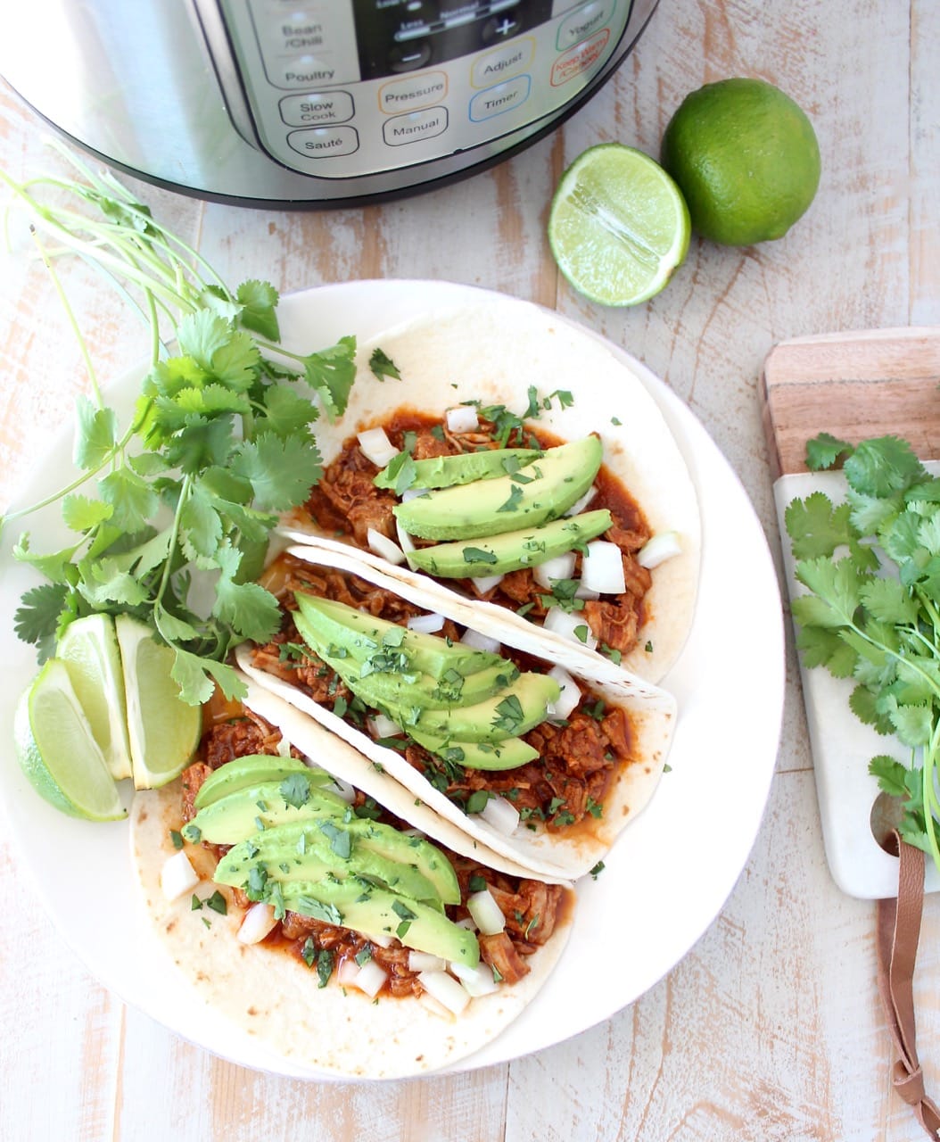 Instant pot pulled pork tacos are easy to make in under an hour with lean pork tenderloin, a delicious combination of spices and a sriracha honey tomato sauce!