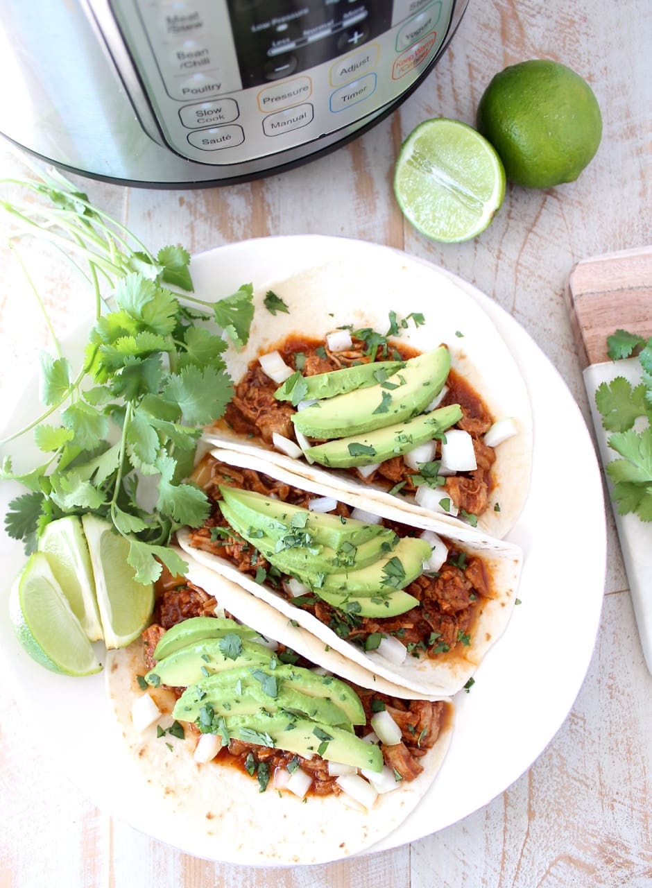 Instant pot pulled pork tacos are easy to make in under an hour with lean pork tenderloin, a delicious combination of spices and a sriracha honey tomato sauce!