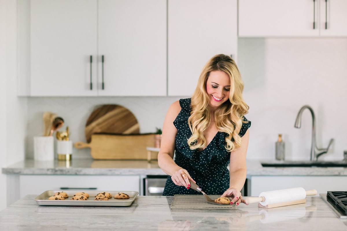 Whitney Bond removing cookies from baking sheet with spatula to place on a cooling rack