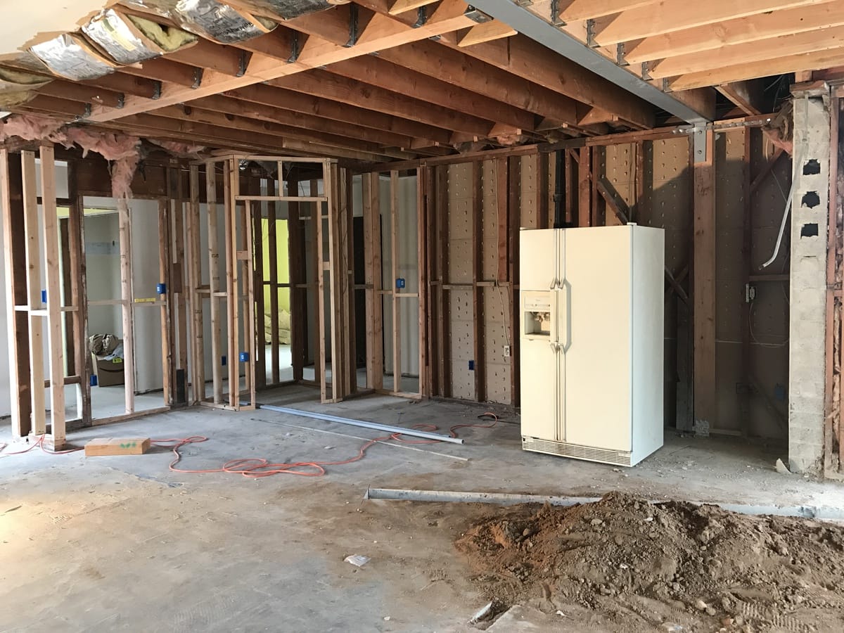 Completely demoed kitchen with studs and concrete gas line channel dug in the concrete 