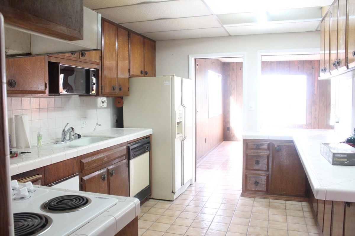 Old kitchen with tile floors and brown wood cabinets