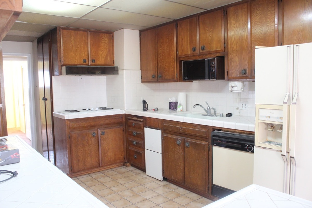 Old kitchen with brown wood cabinets and old appliances