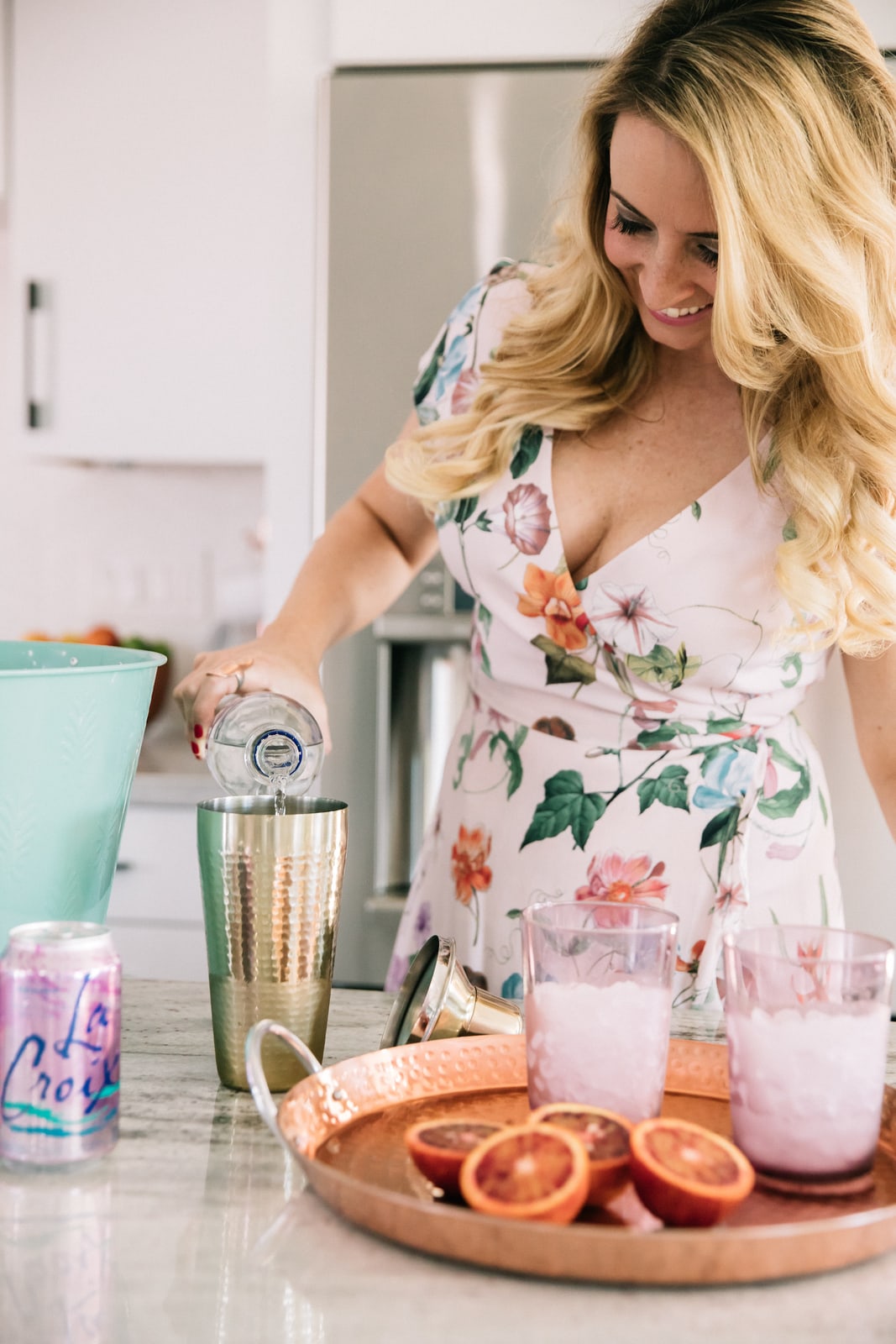 Whitney Bond making cocktails in kitchen with blood oranges, vodka and la croix