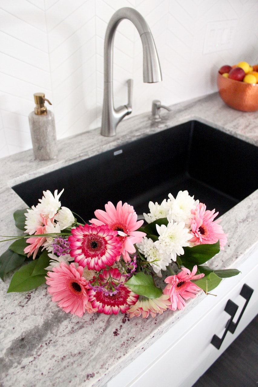 Large kitchen sink with pink and white flowers in the sink